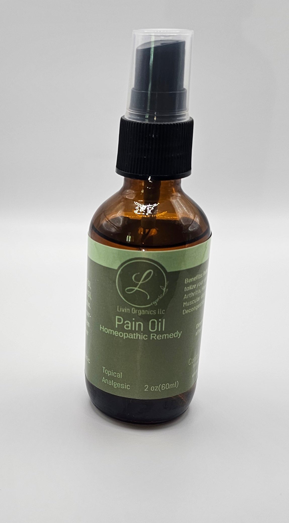 A brown glass bottle with a spray top, labeled "Livin Organics LLC Pain Oil Homeopathic Remedy" in green and white. The bottle contains 2 oz (60ml) of topical analgesic.